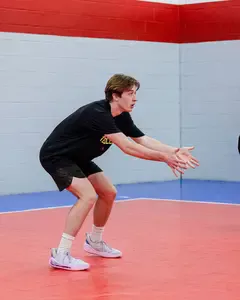 Learn the volleyball ready position for passing where clasped thumbs are pointed to the ground to form a platform with forearms to pass balls in a rally. 
