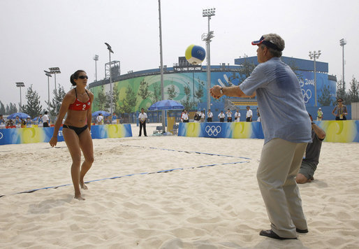President George W. Bush hits a volleyball back to U.S. Women's Beach Volleyball team member Misty May-Treanor, left, during his visit to the Chaoyang Park practice courts Saturday, Aug. 9, 2008, before the U.S. team began their matches at the 2008 Summer Olympics in Beijing.
