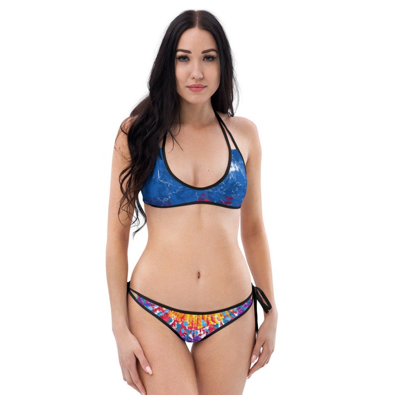 Blue tie dye bikini and one piece swimsuit designs are solids and prints mixed and matched with fun circular and paint splatter multicolored patterns...