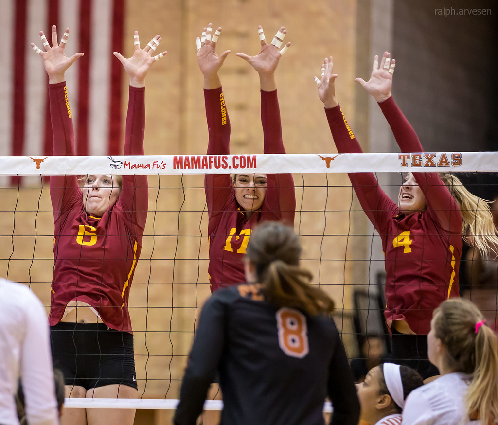 The 3 blockers on the server's side work together to block a player forming a wall with hands, arms, shoulders that extends over the net to stop the ball from entering their side. (Aversen)