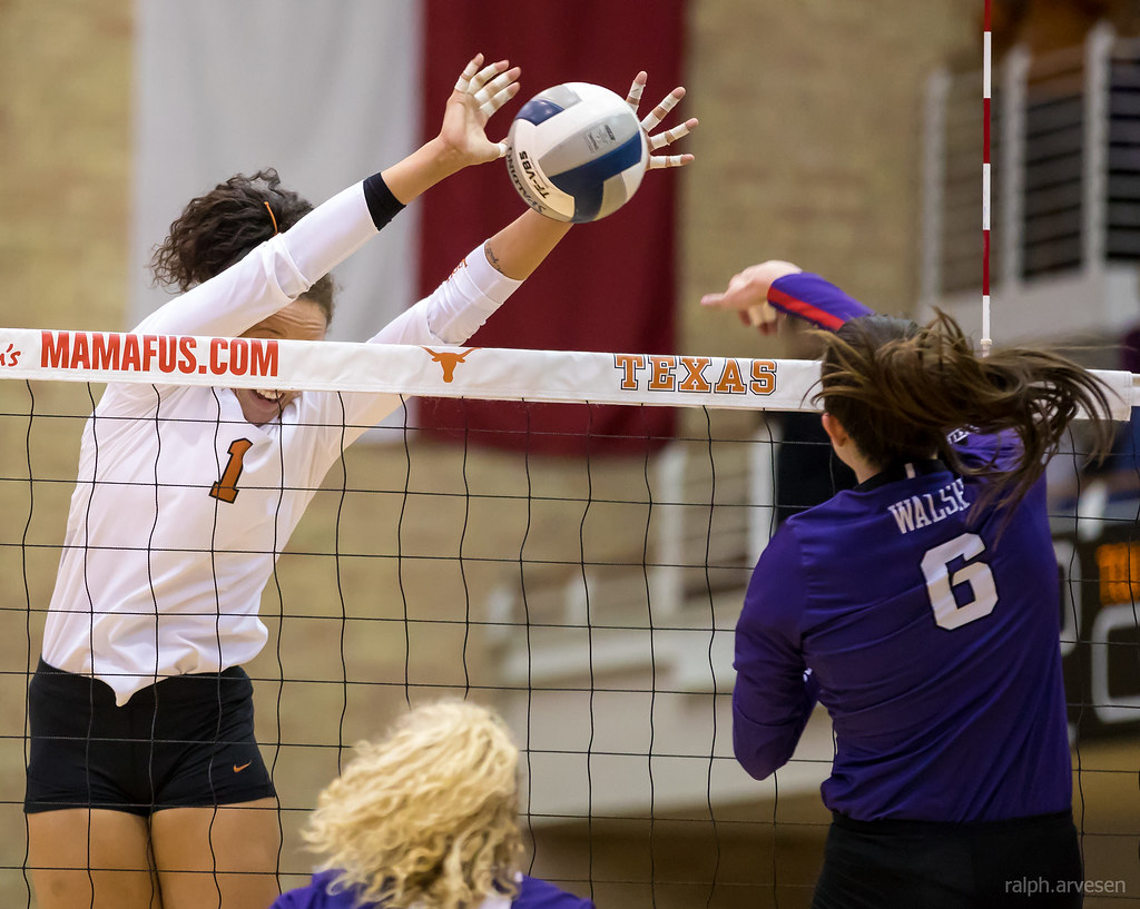 Volleyball Blocking Strategies:
Texas Micaya White gets head and shoulders over the net to stuff block, timing her jump while reading the hitter leaving the hitter no where to go but into the block. (Ralph Arvesen)