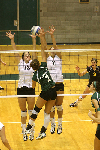 Cleveland State hitter in volleyball attacks the seam between the block.