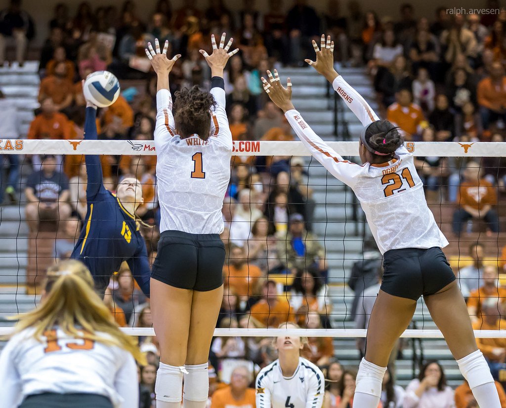 Texas middle blocker (#21) closes the block covers holes between her and outside blocker (Micaya White #1) making it difficult for the opposing hitter to hit the ball between them. (Ralph Arvesen)