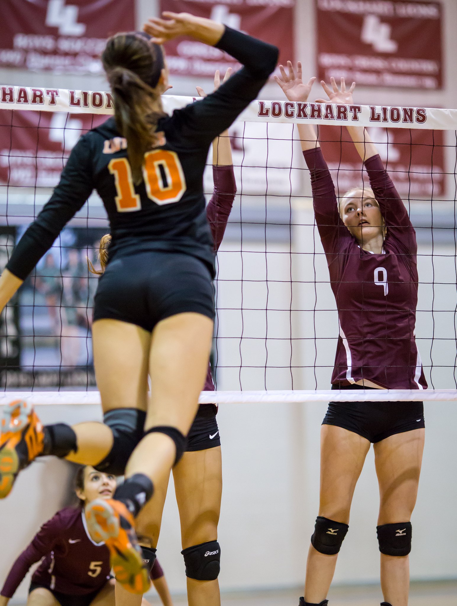 Varsity high school middle watches the hitter while blocking in volleyball game. (Ralph Arvesen)