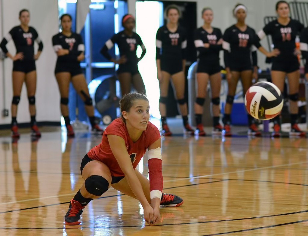 How to dig in volleyball: keep thumbs pointed to the floor, which keeps your arms straight and creates a nice flat platform which you use to dig the ball up into the air (Al Case)